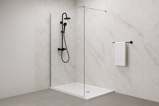 Moderni stiklinė dušo sienelė minimalistiniame vonios kambaryje – skaidrus stiklas, juodi maišytuvai, marmuro sienos.