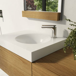 Chromuotas žemas Kohlman Experience QB100E maišytuvas sumontuotas ant baltos praustuvo plokštumos.