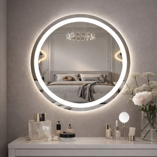 Apvalus apsviestas veidrodis virs kosmetinio staliuko, atspindintis jauku miegamojo interjera su dekoratyviniais sviestuvais ir aksesuarais.