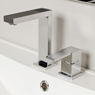 Chromuotas Kohlman Excelent dviejų skylių maišytuvas sumontuotas ant balto praustuvo, matomas minimalus modernus dizainas.