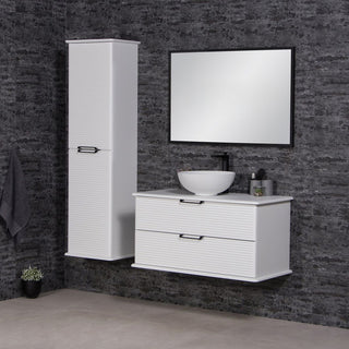 Libra vonios baldai – balta spintele su praustuvu, auksta spinta ir veidrodis ant tamsios sienos.