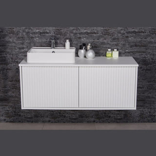 TRETTO 120 cm balta pakabinama vonios spintelė su praustuvu ir plačiu stalviršiu moderniame interjere.