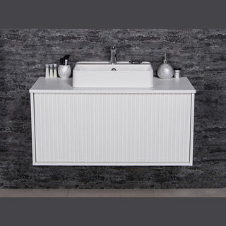 TRETTO 100 cm pakabinama balta vonios spintelė su praustuvu prieš tamsią sieną.